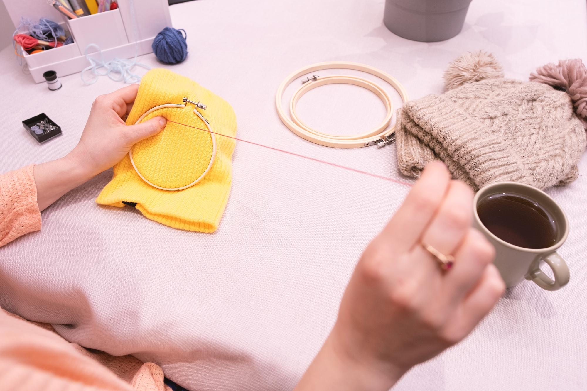 studio hands arranging threads and hoops on a table